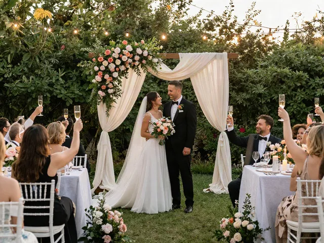 Event rentals for a stunning wedding ceremony featuring floral decor and joyful couple.